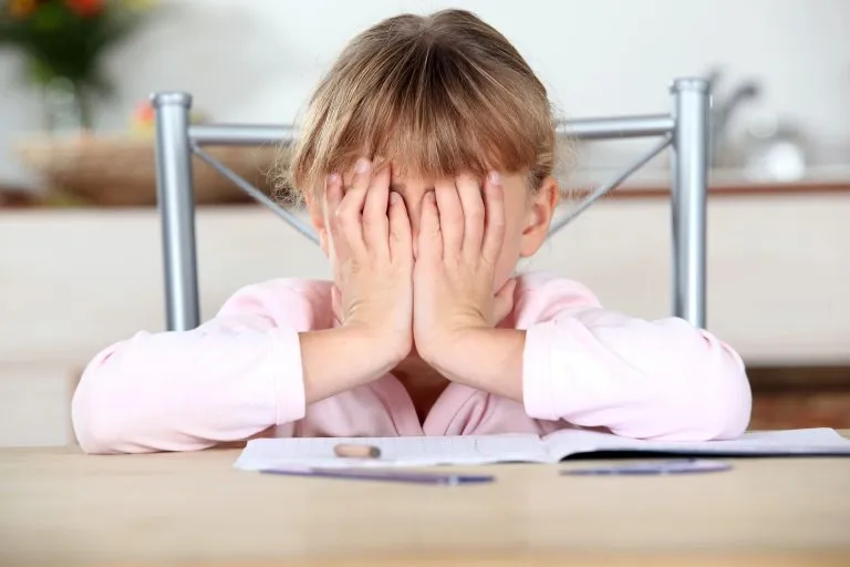 Frustrated child with ADHD unable to complete her homework